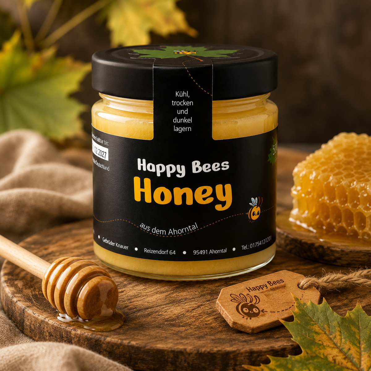 Feincremiger Blütenhonig von HappyBees mit Honigwabe und Honiglöffel